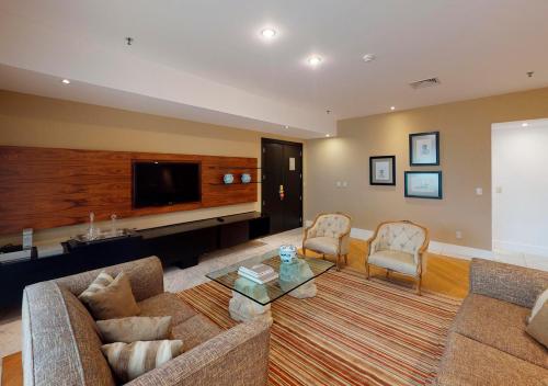 a living room with a couch and a tv at Gran Estanplaza Berrini in Sao Paulo