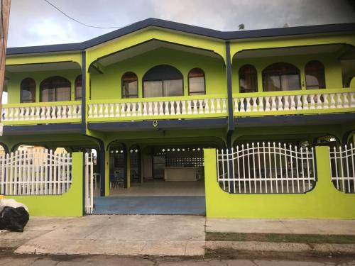 a yellow house with a white fence in front of it at Combate Green House in Cabo Rojo
