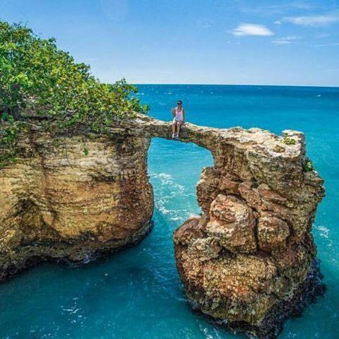 a man standing on a rock in the ocean at Combate Green House in Cabo Rojo