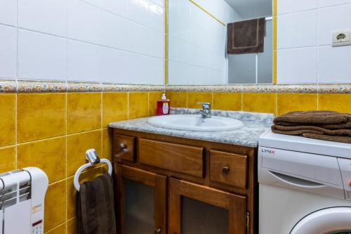 a bathroom with a sink and a washing machine at Santa Cruz in Broto
