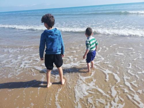 two boys standing in the sand on the beach at MAR JÓNICA in Denia