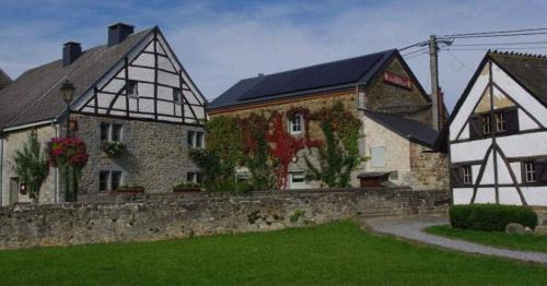 a house with a stone wall next to a building at Mante et Nana in Durbuy