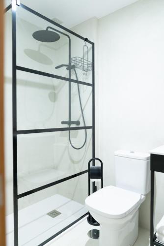 a bathroom with a toilet and a glass shower at Pacificio Beachfront in Málaga