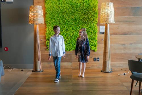 a boy and a girl walking down a hallway at Novotel Curitiba Batel in Curitiba