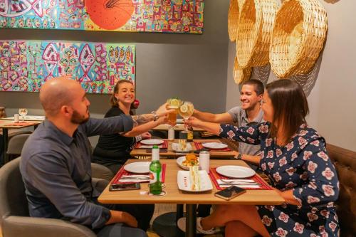 a group of people sitting at a table drinking wine at Novotel Curitiba Batel in Curitiba