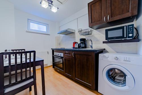 eine Küche mit einer Waschmaschine und einer Mikrowelle in der Unterkunft Old City Lux 2 in Braşov