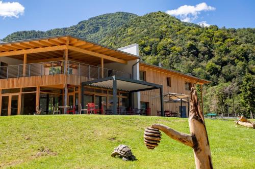 une maison sur une colline avec une statue devant elle dans l'établissement Bosc del Meneghì, à Ledro