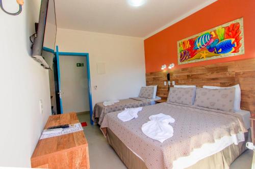 a bedroom with a bed and a couch and a table at Kaliman Pousada in Ubatuba