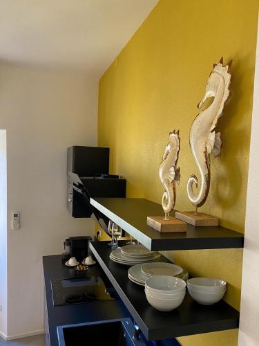 a kitchen with a counter with dishes on a shelf at La Ripa Camere Vernazza in Vernazza