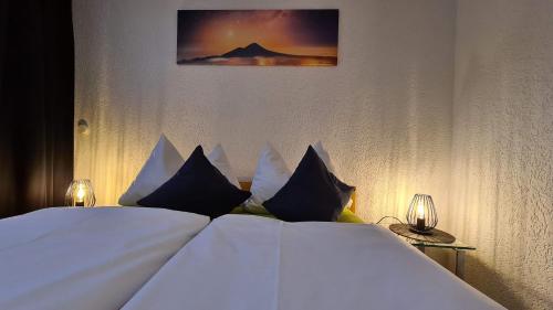 a bed with white sheets and pillows in a room at Pension Maintal Eltmann in Eltmann