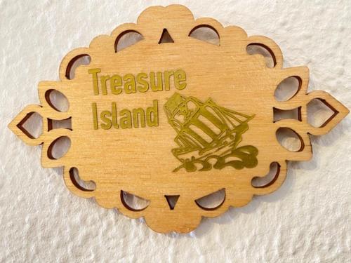 un cartello di legno con un'isola del tesoro sopra di Frankie’s House a Ghiffa