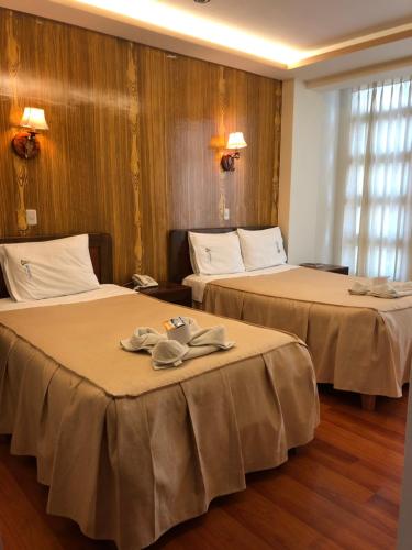 two beds in a hotel room with towels on them at Hotel Imperial in Juliaca