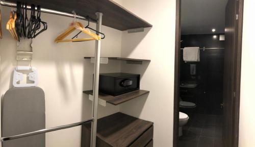 a bathroom with a toilet and a sink and a room at LUXURY APARTMENT with amenities in chicó bogotá in Bogotá