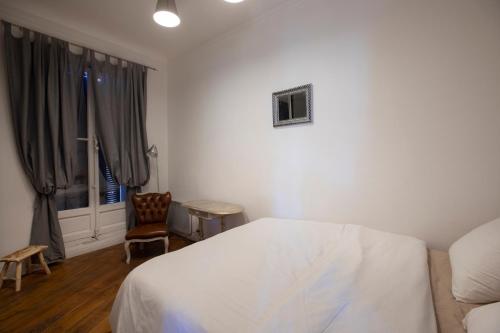 een slaapkamer met een bed, een stoel en een raam bij Cosy République in Marseille