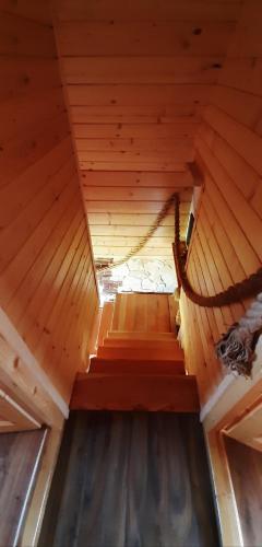 an attic with a hammock in a wooden cabin at Babiogórskie Domki in Lipnica Wielka