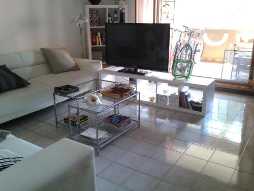 a living room with a white couch and a television at Su Planu in Cagliari