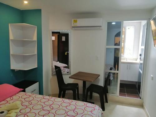 1 dormitorio con 1 cama, mesa y sillas en Hotel Español Neiva en Neiva