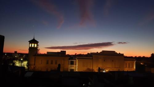 a building with a clock tower at sunset at Hotel Los Angeles in Gualeguaychú