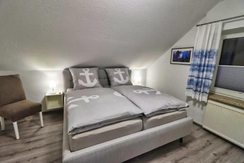 ein Schlafzimmer mit einem Bett, einem Stuhl und einem Fenster in der Unterkunft Ferienkate Norddeich in Norddeich