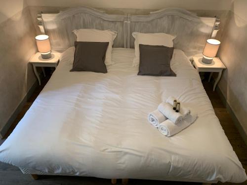 a white bed with two towels and two lamps at Au Fin Gourmet in Le Croisic