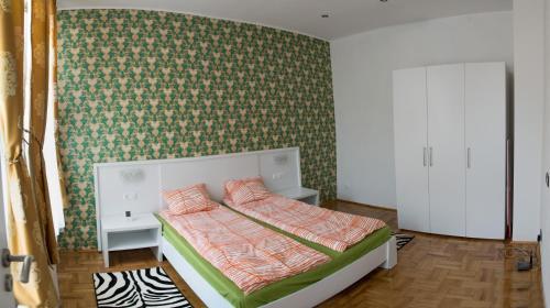 a bedroom with a bed with a green wall at Sibiu Residence in Sibiu