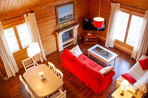 a living room with a red couch and a table at Quinta de Argos in Cehegín