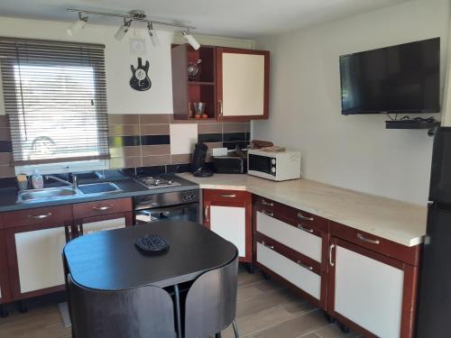 une cuisine avec un comptoir et une table à l'intérieur dans l'établissement Petite Maison Chalet à 100 m de la petite mer de Gâvres, à Riantec