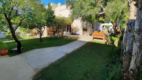un jardín con un banco en el césped en Rada Tilly Apart Hotel, en Rada Tilly