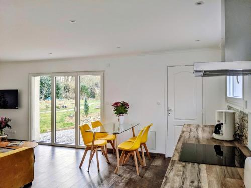 een keuken en eetkamer met een tafel en stoelen bij Maison Blanche en Côte de Nacre in Mathieu