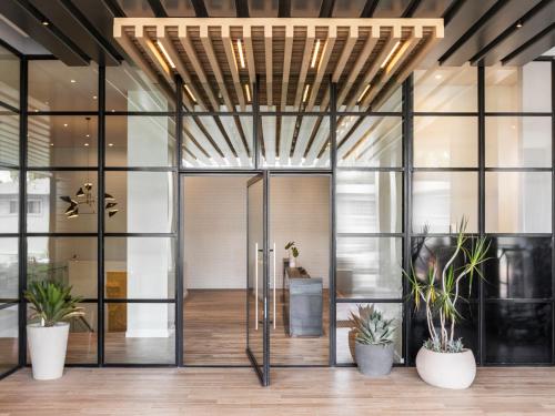 an office lobby with glass doors and potted plants at Kimpton Everly Hotel Hollywood by IHG in Los Angeles