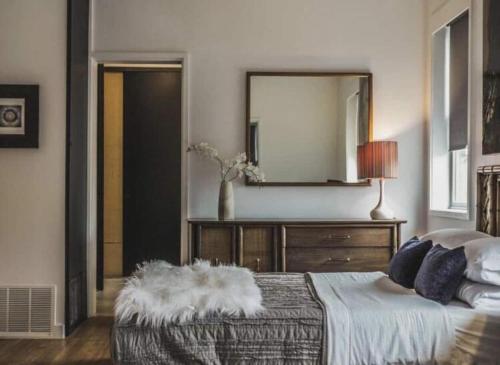 a bedroom with a bed with a mirror and a dresser at Bishop Arts Hotel in Dallas