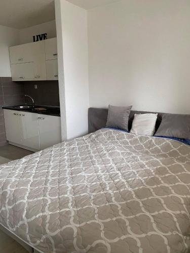 a bedroom with a large bed and a kitchen at Apartman Travnik in Travnik