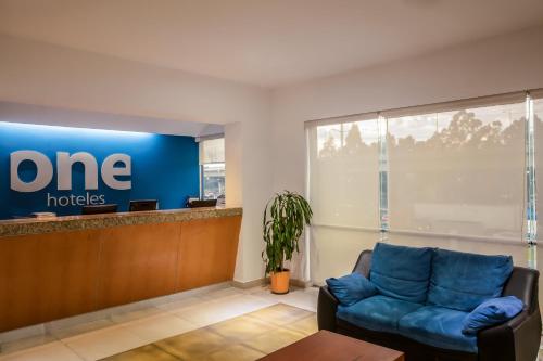 a waiting room at a one hotel with a couch at One Puebla FINSA in Puebla