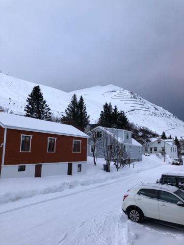 a car parked in front of a house in the snow at Hlíðarvegur 20 - Gagginn in Siglufjörður