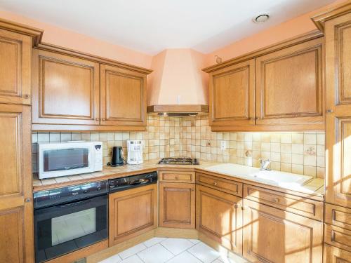 - une cuisine avec des placards en bois et un four micro-ondes dans l'établissement Holiday Home Saint-Nexans near Monbazillac, à Saint-Nexans