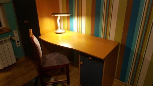 a desk with a lamp and a chair in a room at Aare kodumajutus Sandri tuba in Tammiku