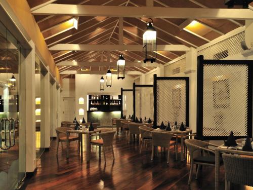 a dining room with tables and chairs and lights at Cinnamon Lodge Habarana in Sigiriya
