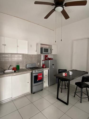 a kitchen with a stove and a table and a ceiling fan at DEPARTAMENTOS GARI in Córdoba