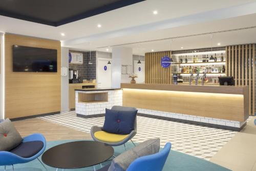 a restaurant with a bar with blue chairs and a counter at Holiday Inn Express St. Albans - M25, Jct.22 in Saint Albans