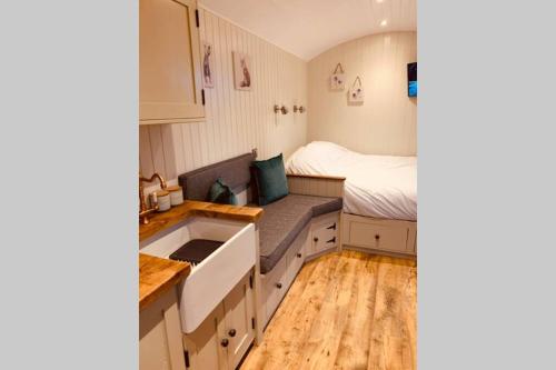 een kleine keuken met een wastafel en een bed in een kamer bij Lle Mary - Beautiful views, Hot tub, Secluded, Dog Welcome, Barmouth in Llanddwywe