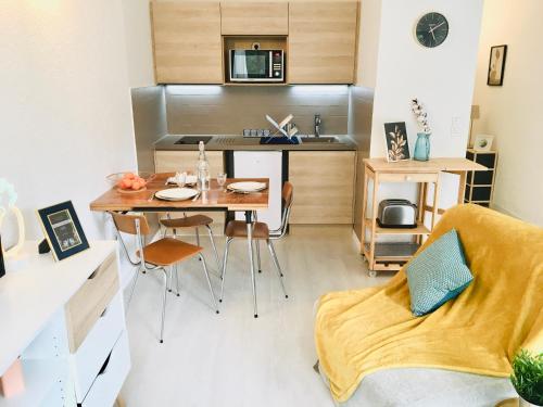 une petite cuisine et salle à manger avec une table et des chaises dans l'établissement F2 calme refait à neuf à 5mn de la plage avec parking, au Grau-dʼAgde