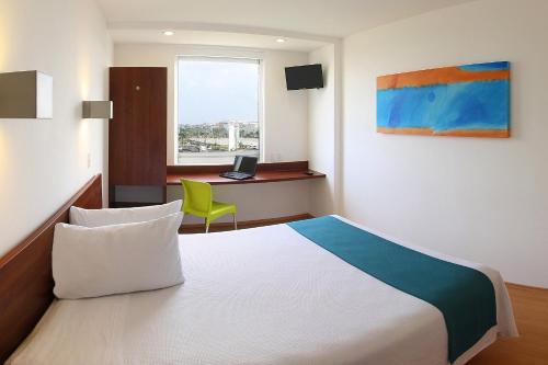 A bed or beds in a room at One Xalapa Las Animas