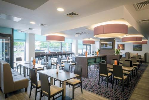 a restaurant with tables and chairs and a bar at Holiday Inn Express Middlesbrough - Centre Square by IHG in Middlesbrough