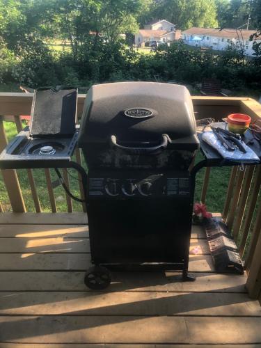 a grill sitting on a porch with a bbq at The HideAway Tiny Cabin in East Durham