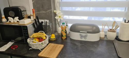 una barra de cocina con microondas y una cesta de fruta en Apartment Manhattan, en Tarnowskie Góry