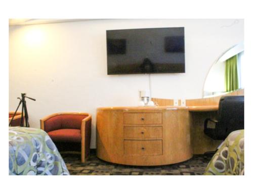 a hotel room with a television and a dresser with a desk at Hotel Mandarin Carton in Mexico City