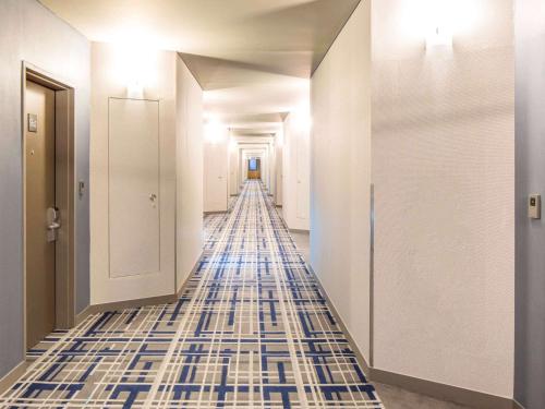 a hallway with blue and white tile flooring at Ibis Ambassador Suwon in Suwon