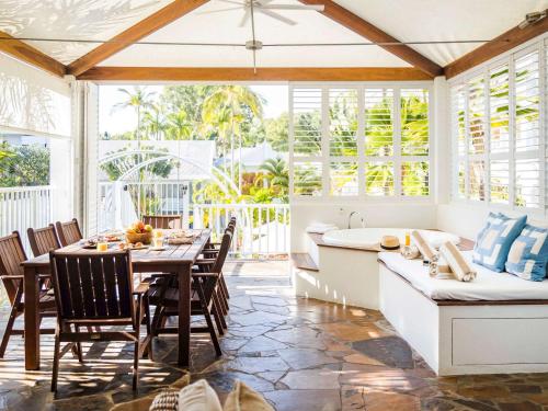 a kitchen and dining room with a table and a tub at The Reef House Adults Retreat - Enjoy 28 Complimentary Inclusions in Palm Cove