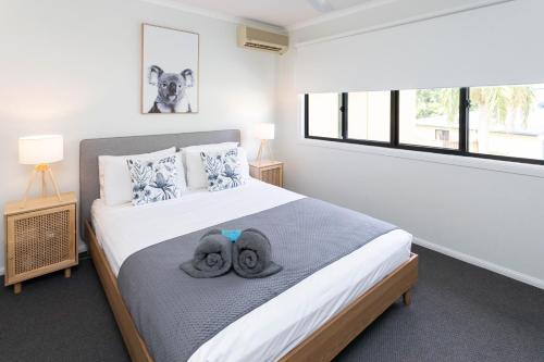 a bedroom with a bed with two towels on it at Paradise Palms CLOSE TO BEACH, WIFI, 2 BEDROOMS in Airlie Beach
