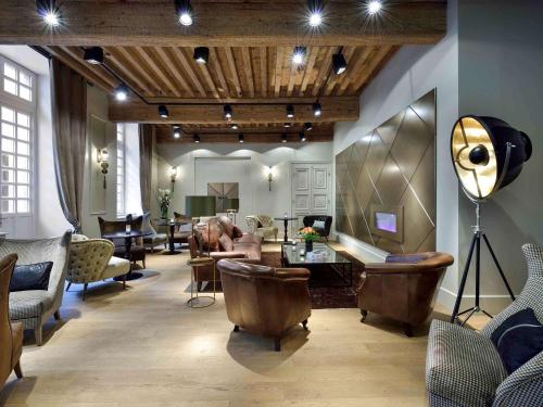 a living room with a lot of chairs and tables at La Cour des Consuls Hotel & Spa Toulouse - MGallery Collection in Toulouse